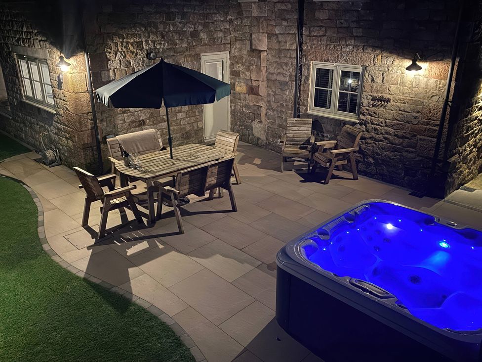 An outdoor area with a hot tub and a dining table at Small Lane Cottage Blackwood Hill near Endon