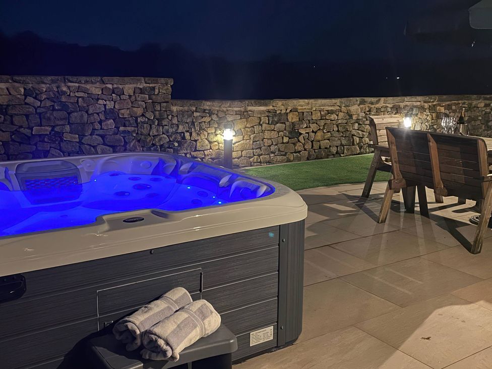 A hot tub with towels on a bench in an outdoor area at Small Lane Cottage Blackwood Hill near Endon