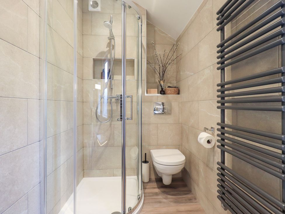 A bathroom with a shower, toilet, and towel rack at West View near Leasgill