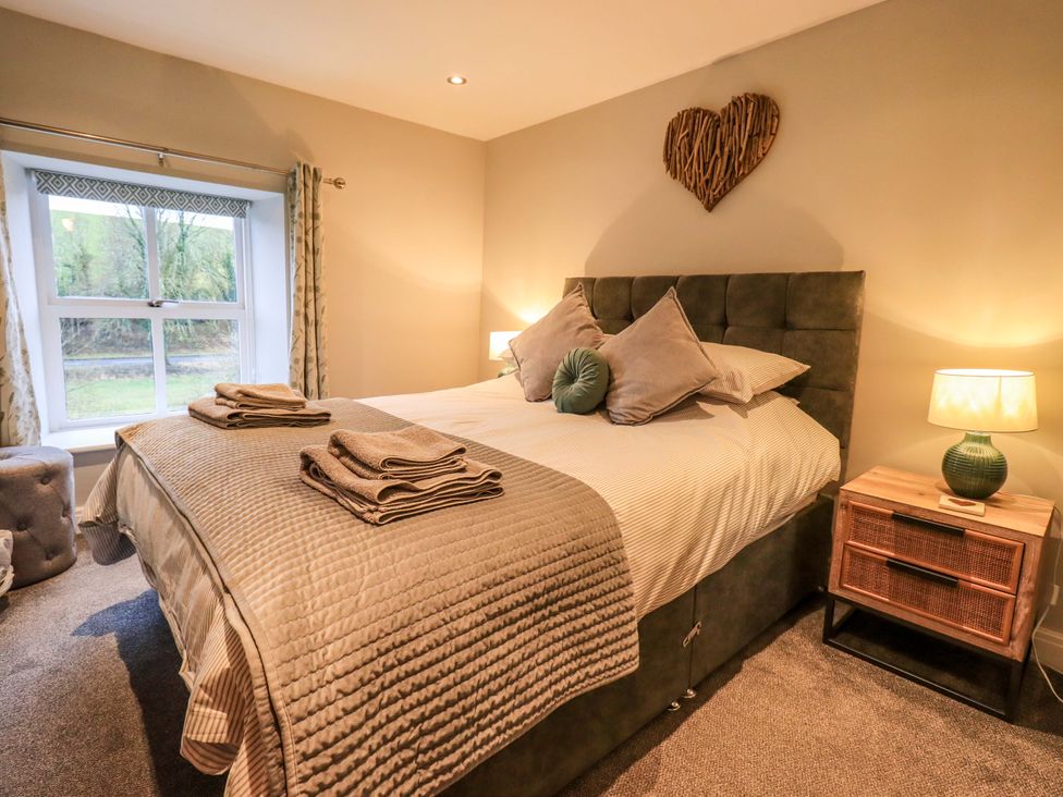 A bedroom with a bed and bedside table at West View Leasgill near Milnthorpe
