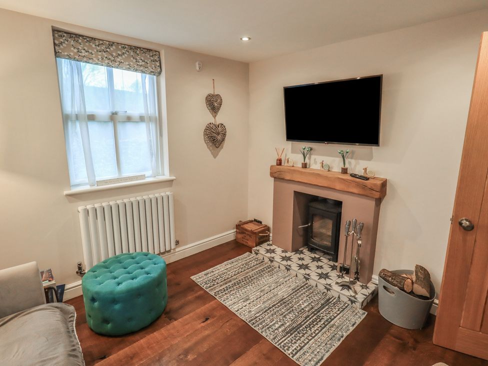 A living room with a television and fireplace at West View Leasgill near Milnthorpe