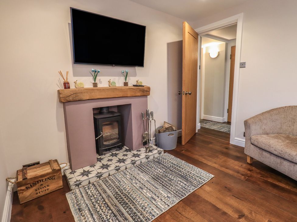 A living room with a fireplace and television at West View in Leasgill near Milnthorpe