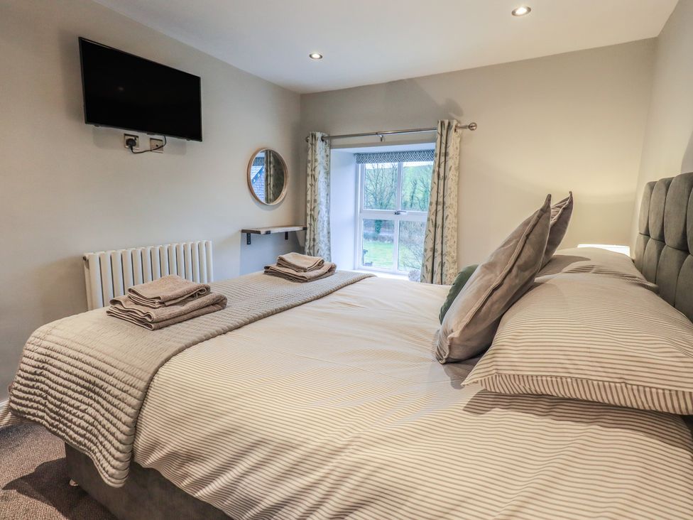 A bedroom with a bed and television at West View in Leasgill near Milnthorpe