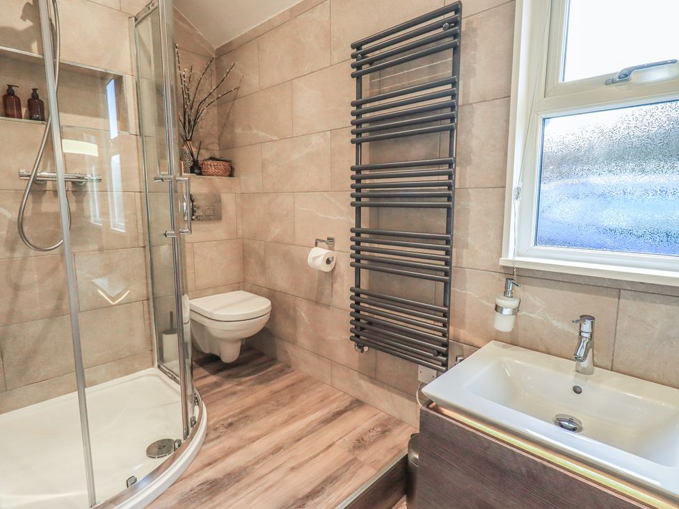 A bathroom with shower, toilet, sink and towel rail at West View Leasgill near Milnthorpe
