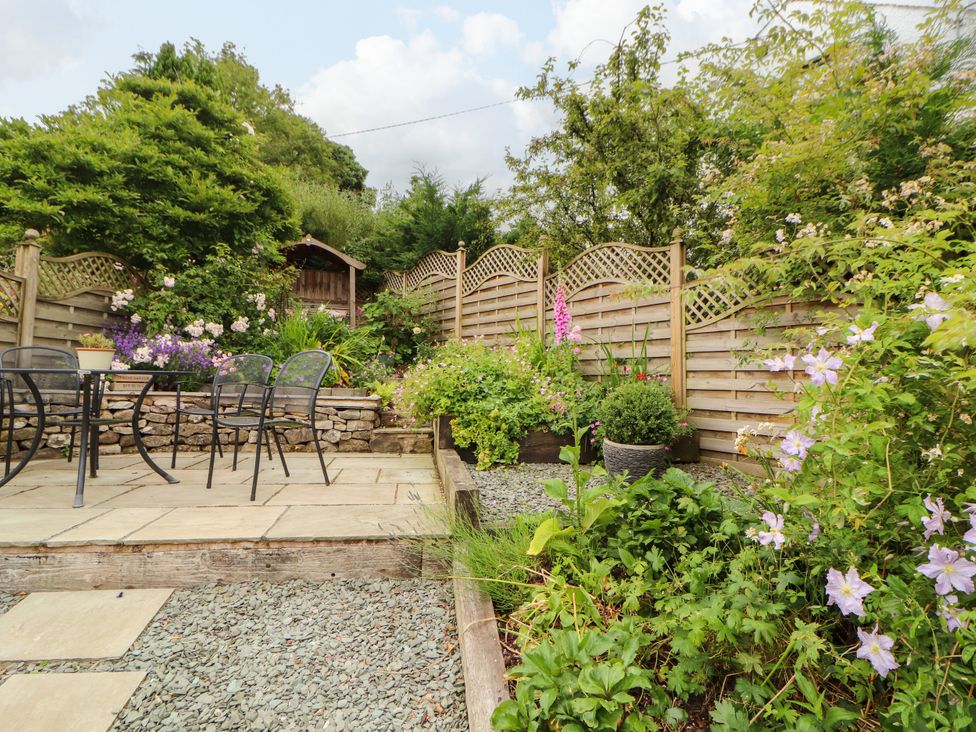 A garden with a seating area and flower beds at West View, Leasgill near Milnthorpe