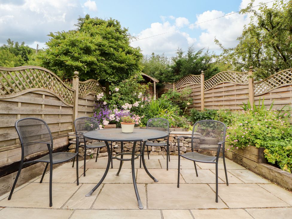 A garden with a table and chairs surrounded by plants at West View Leasgill near Milnthorpe