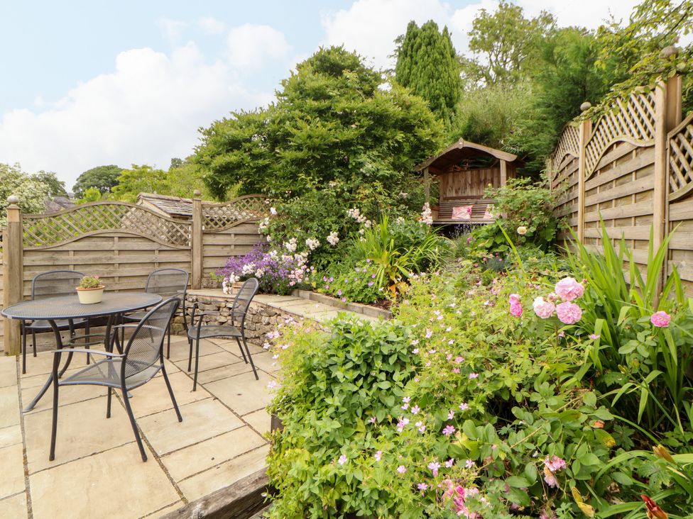 A garden with a table, chairs, and flowers at West View Leasgill near Milnthorpe