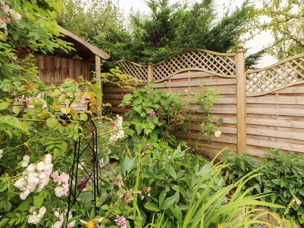 A garden with a shed and flowering plants at West View in Leasgill near Milnthorpe