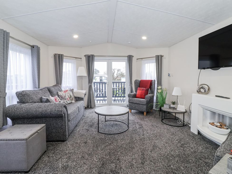 A living room with a sofa and coffee table at Happy Daze in Carnaby near Bridlington