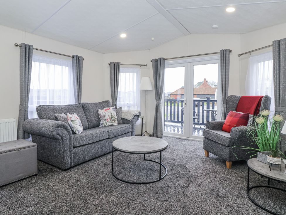A living room with a sofa and armchair at Happy Daze Carnaby near Bridlington