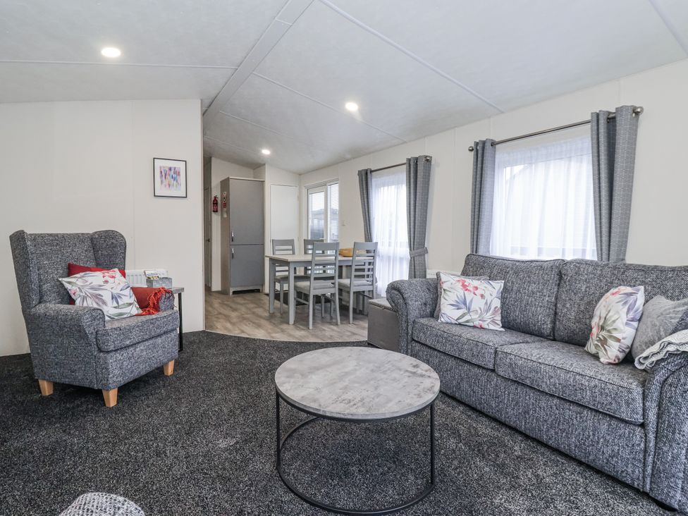 A living room with a sofa and coffee table at Happy Daze in Carnaby near Bridlington