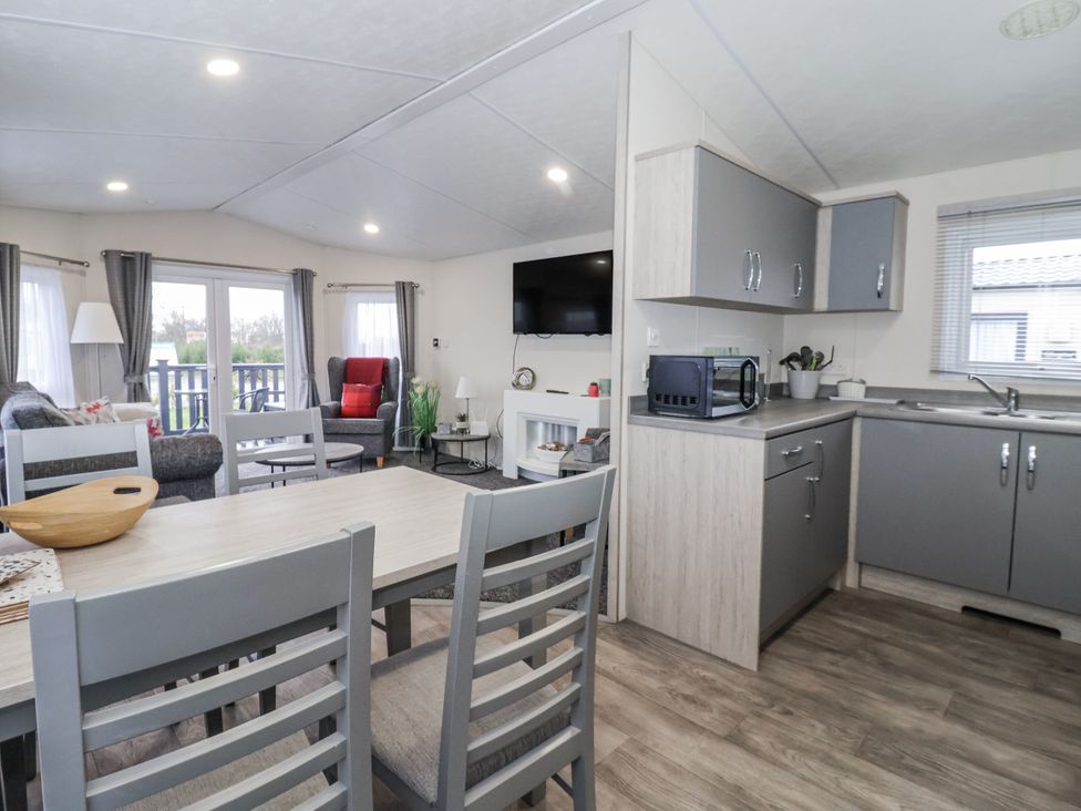 A living room and kitchen area with seating and appliances at Happy Daze in Carnaby near Bridlington