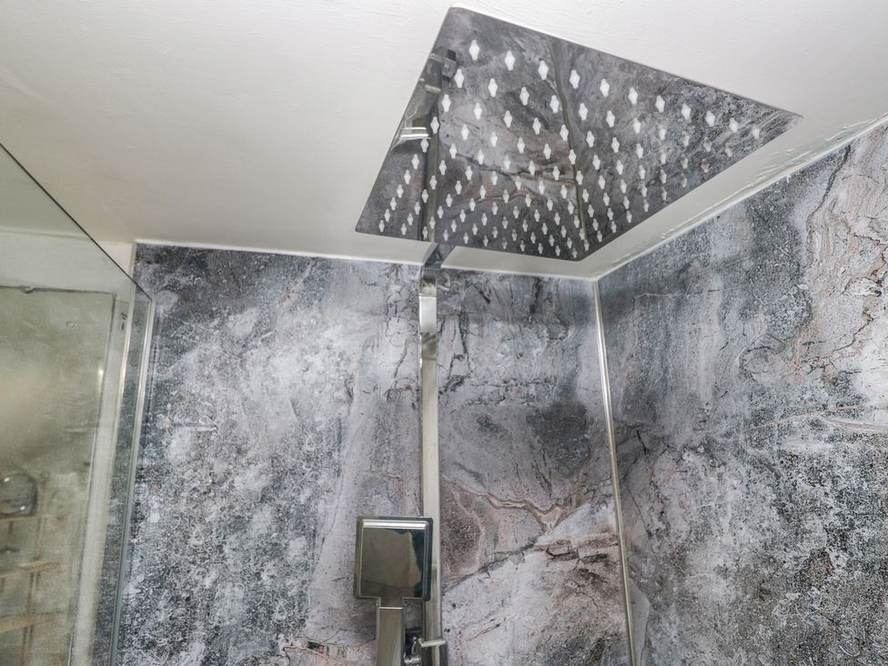 A shower setup with a large shower head and modern faucet at Bay Tree Cottage in Ambleside