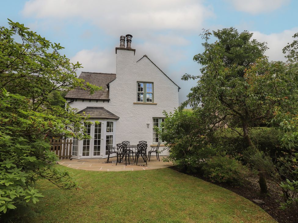 A house with a garden and seating area at The Old Post House at Low Stott Park near Newby Bridge