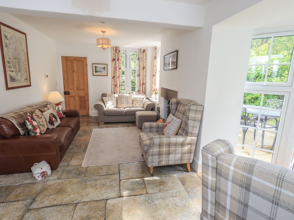 A living room with a sofa and armchairs at The Old Post House at Low Stott Park near Newby Bridge