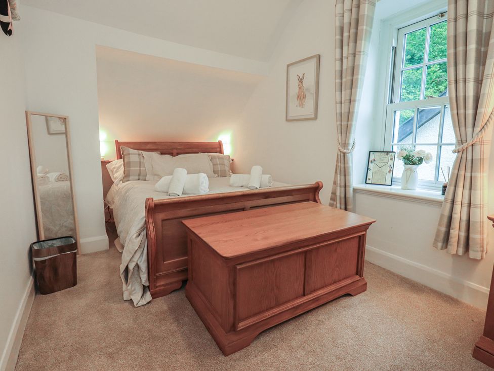 A bedroom with a bed and a window at The Old Post House at Low Stott Park near Newby Bridge