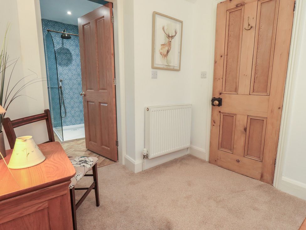 A hallway with a door and radiator at The Old Post House at Low Stott Park