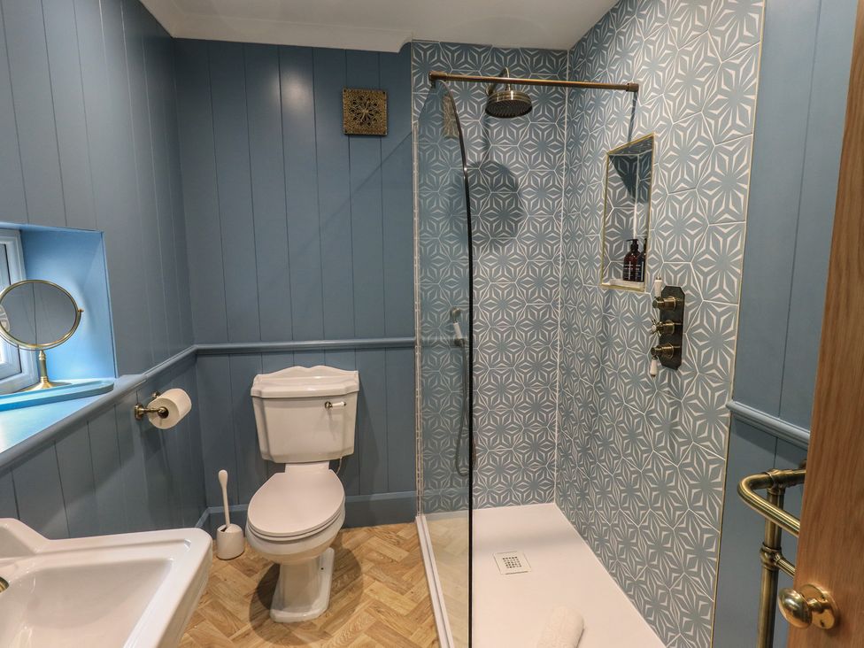 A bathroom with a shower and sink at The Old Post House at Low Stott Park near Newby Bridge