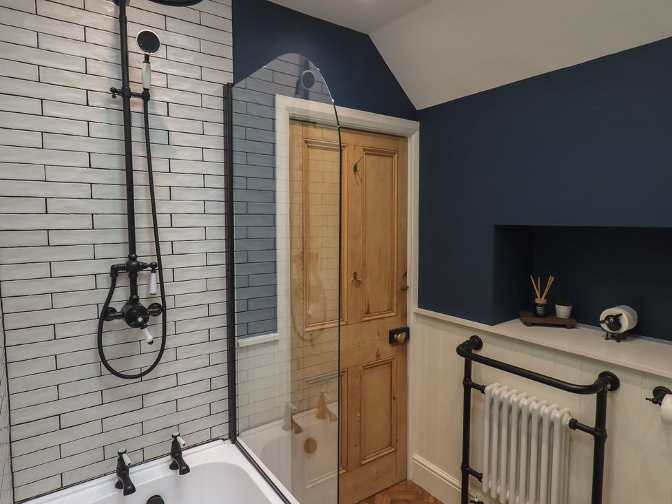 A bathroom with a bathtub and shower at The Old Post House at Low Stott Park near Newby Bridge