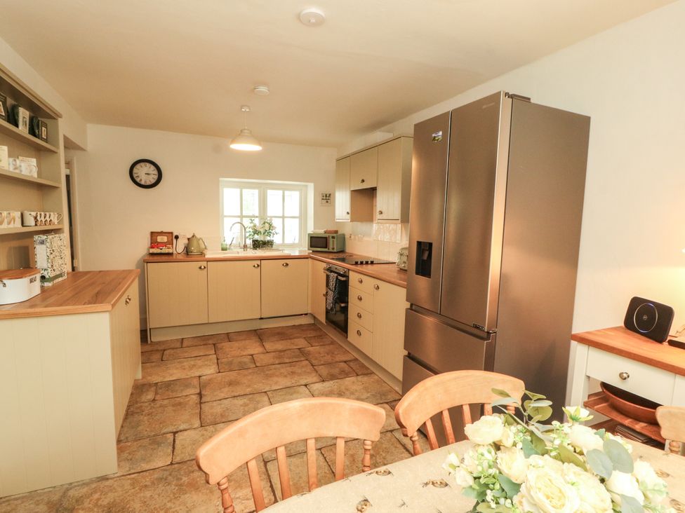 A kitchen with a table and chairs at The Old Post House at Low Stott Park near Newby Bridge