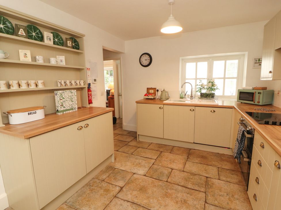 A kitchen with cabinets and a sink at The Old Post House at Low Stott Park near Newby Bridge