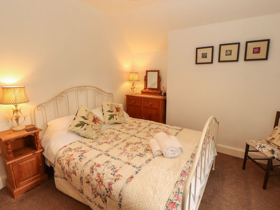 A bedroom with a bed and nightstand at The Old Post House at Low Stott Park near Newby Bridge