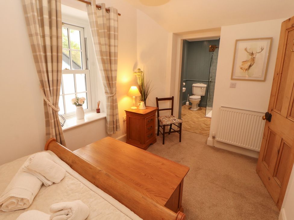 A bedroom with a bed and lamp at The Old Post House at Low Stott Park near Newby Bridge