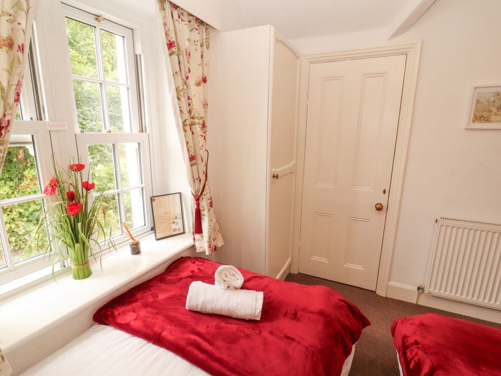 A bedroom with beds and window at The Old Post House at Low Stott Park near Newby Bridge
