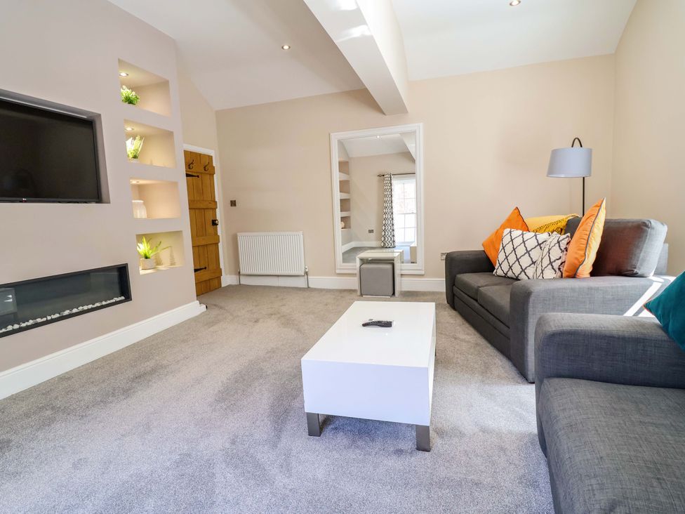 A living room with a sofa and coffee table at Carriage House Capesthorne near Chelford