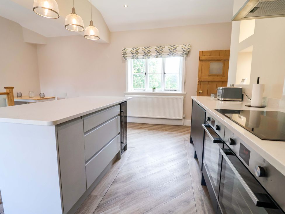 A kitchen with a central island and appliances at Carriage House in Capesthorne near Chelford