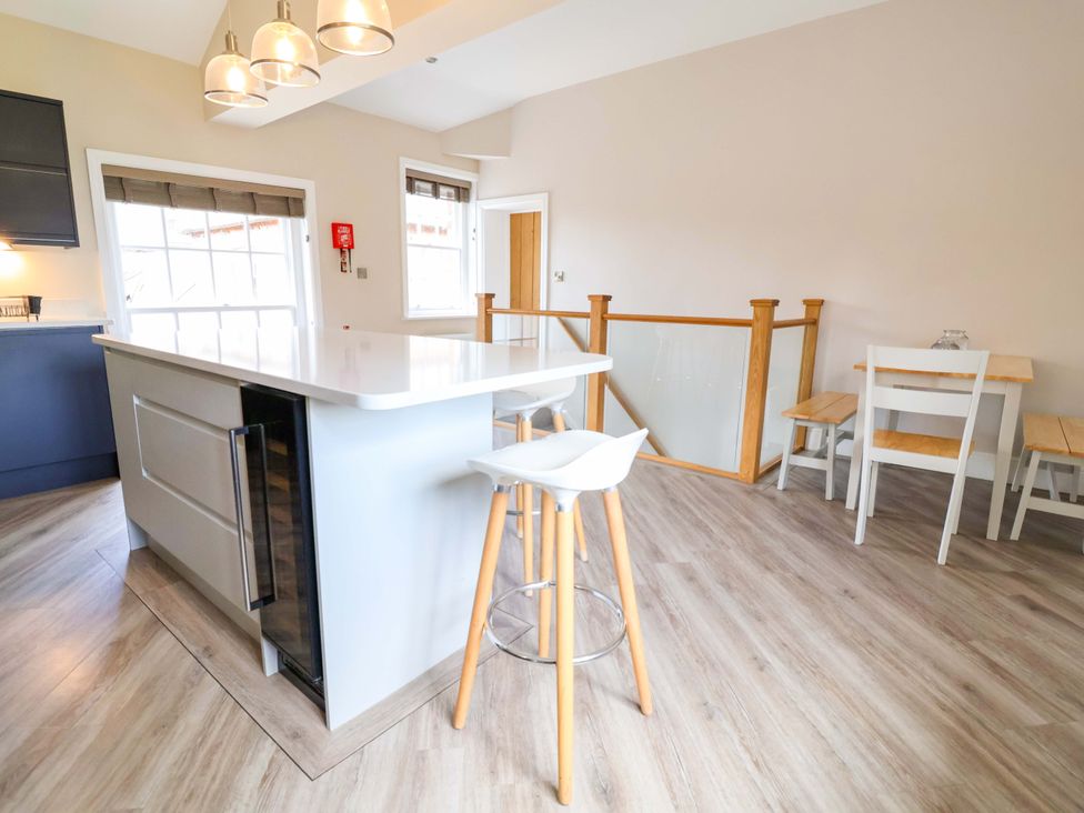 A kitchen with an island and seating at Carriage House in Capesthorne near Chelford
