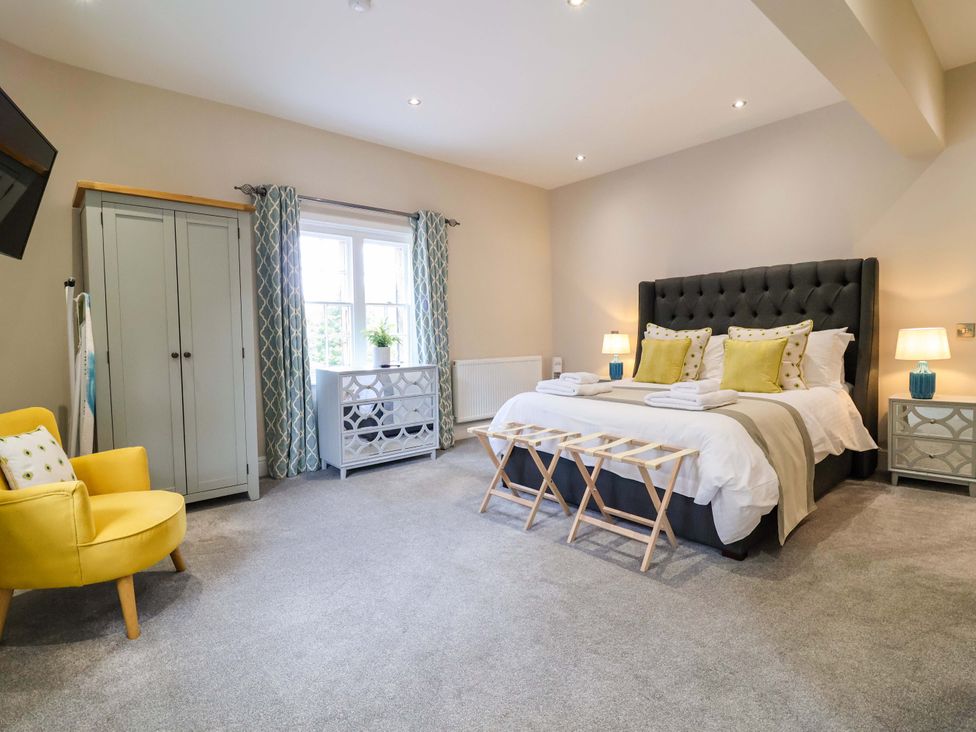A bedroom with a bed and wardrobe at Carriage House in Capesthorne near Chelford