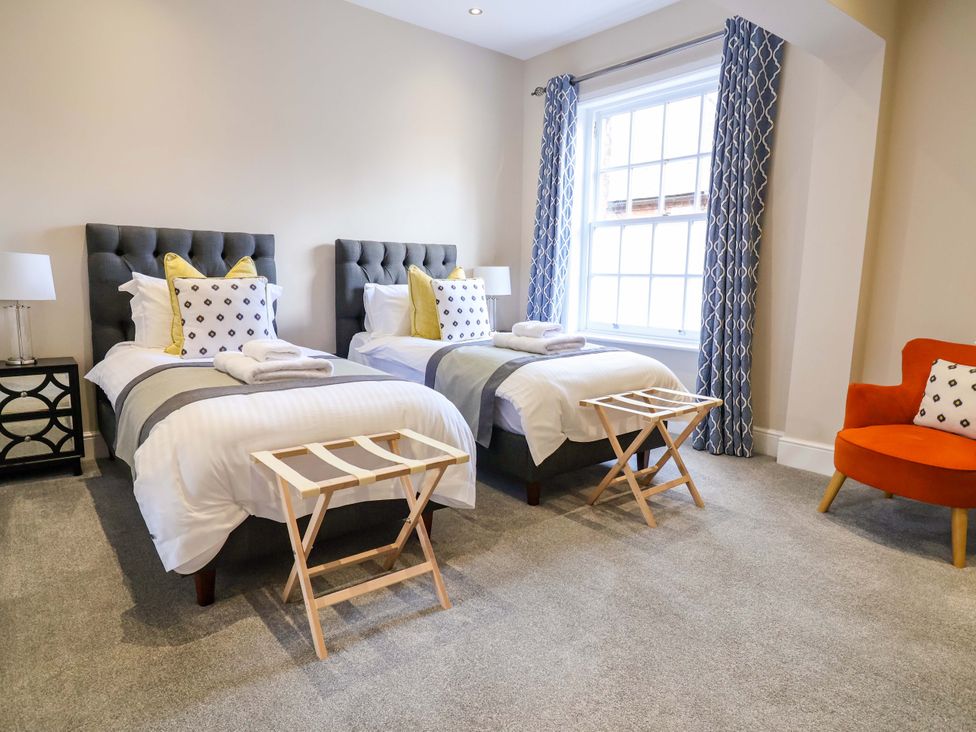 A bedroom with two beds and a window at Carriage House, Capesthorne near Chelford