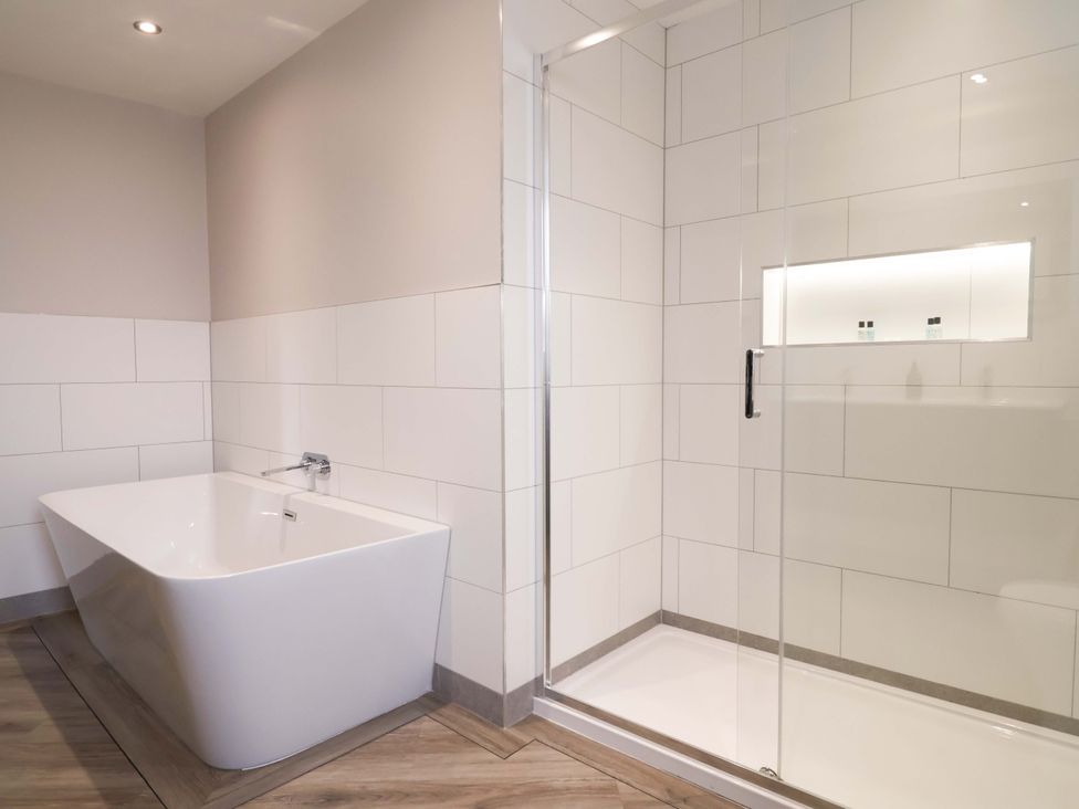 A bathroom with a bathtub and shower enclosure at Carriage House in Capesthorne near Chelford
