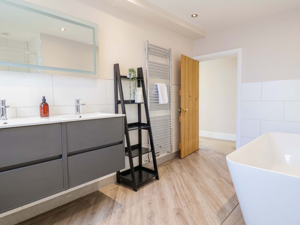 A bathroom with a wash basin and bathtub at Carriage House in Capesthorne near Chelford
