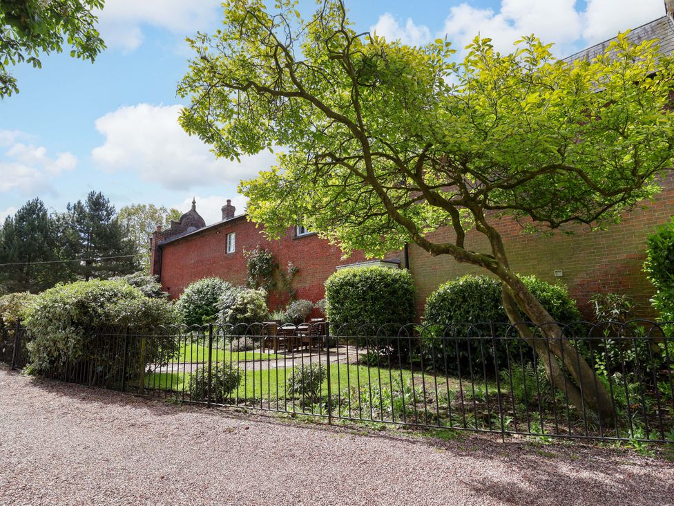 A garden with a tree and patio furniture at Carriage House in Capesthorne near Chelford