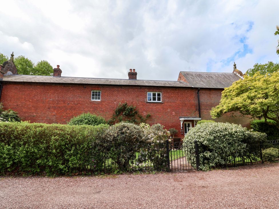 An outdoor view of a garden path and brick wall at Carriage House near Chelford