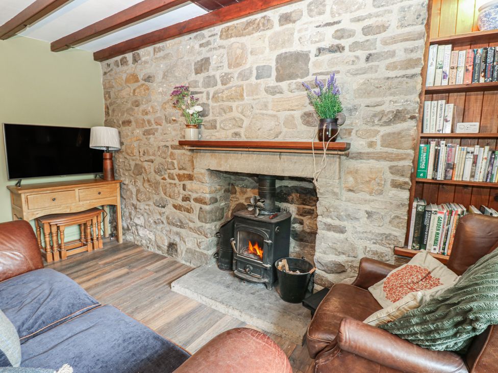 A living room with a fireplace and bookshelf at Banklands in Barnard Castle