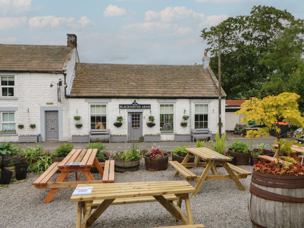 An outdoor seating area with tables and planters at Blacksmiths Arms in Barnard Castle