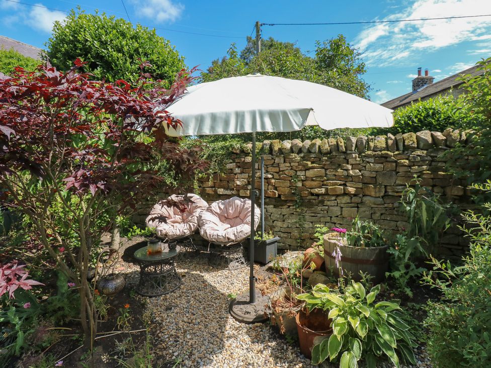 A garden with seating and an umbrella at Banklands Mickleton, Teesdale