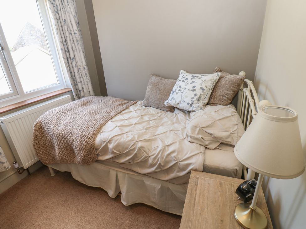 A bedroom with a bed and a lamp at Banklands in Mickleton, Teesdale