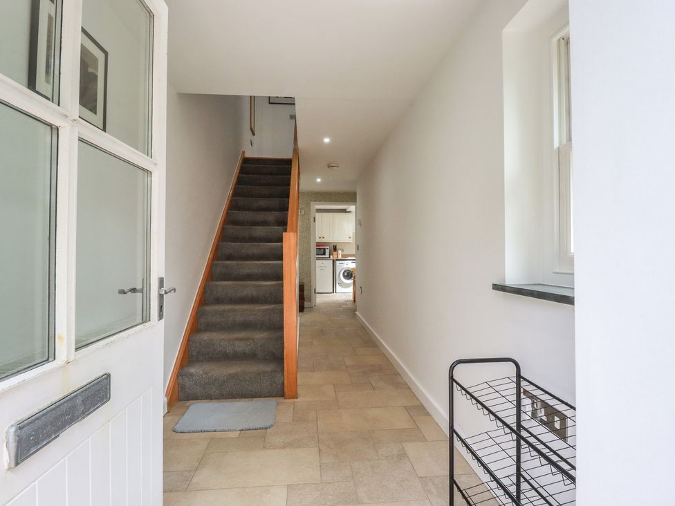 A hallway with stairs and a washing machine at 15 Boscaswell Downs Pendeen