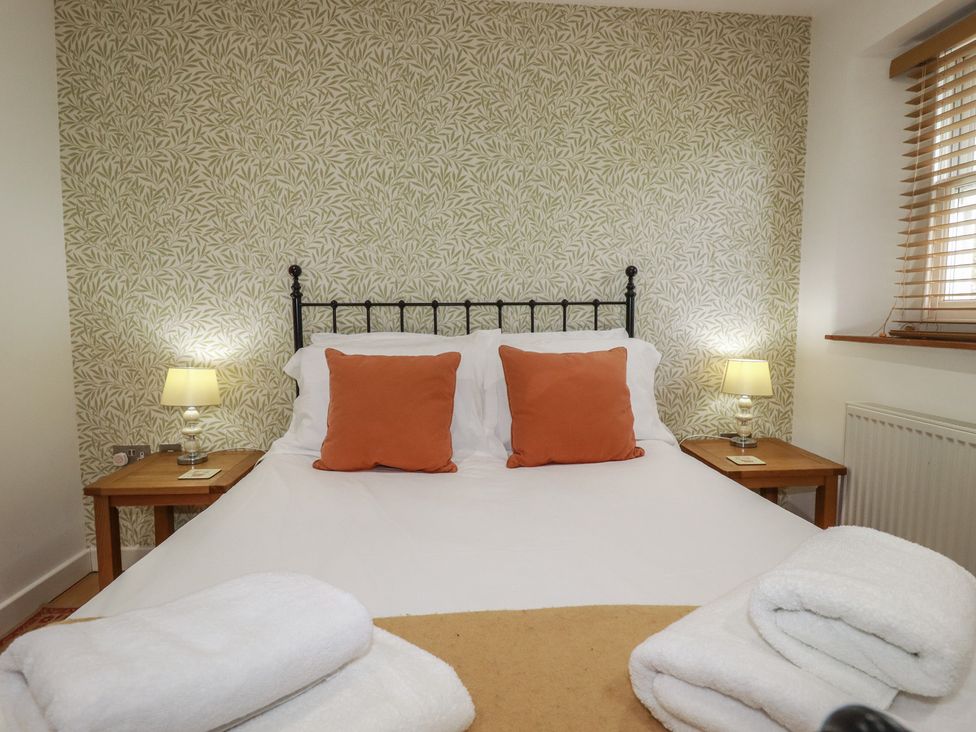 A bedroom with a bed and lamps at 15 Boscaswell Downs in Pendeen