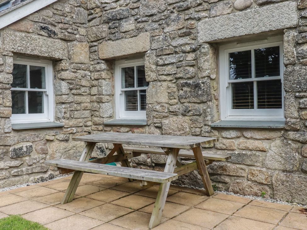 An outdoor area with a stone wall and a picnic table at 15 Boscaswell Downs Pendeen