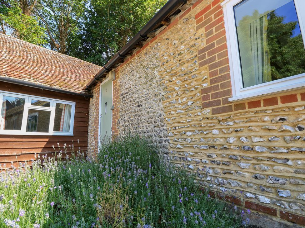 An exterior view showing a door and window with lavender plants at Byre Cottage 3 Sullington near Storrington