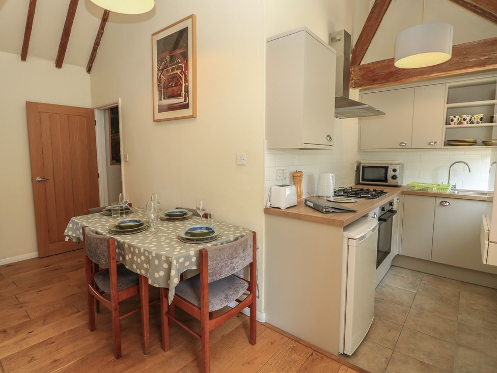 A kitchen with a dining table and chairs at Byre Cottage 3 Sullington near Storrington