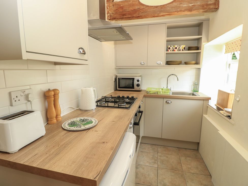 A kitchen with cabinets and appliances at Byre Cottage 3 Sullington near Storrington