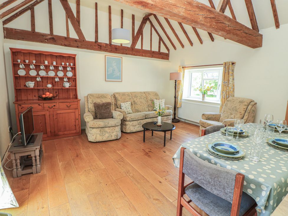 A living room with a sofa, chairs, and a dining table at Byre Cottage 3 Sullington near Storrington