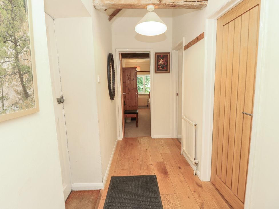 A hallway with wooden flooring and a door at Byre Cottage 3 Sullington near Storrington