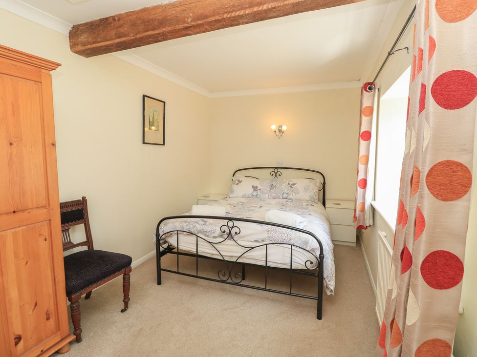 A bedroom with a bed and wardrobe at Byre Cottage 3 Sullington near Storrington